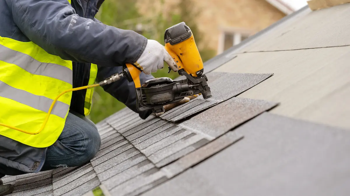 Professional roofer working on a steeply pitched residential roof
