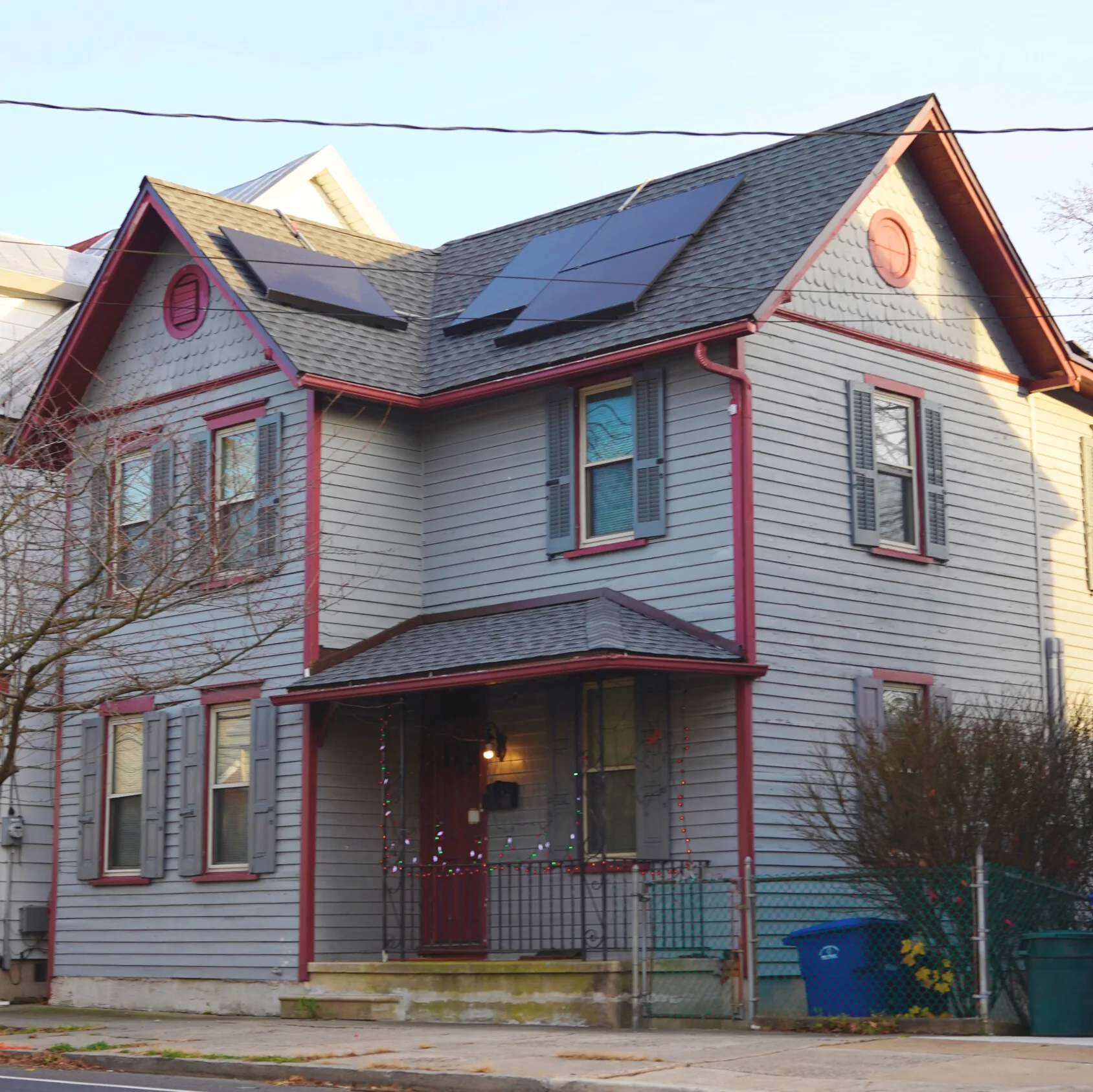 Two-story home with rooftop solar panels installed on an asphalt shingle roof