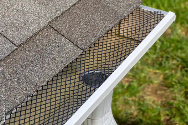 Mesh gutter guard installed on residential gutter to block leaves and debris while allowing proper water flow